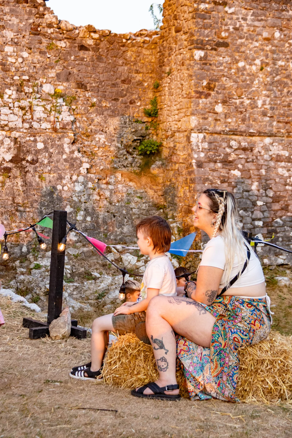 A child and adult enjoying entertainment outside Weobley Castle at JOPOFEST